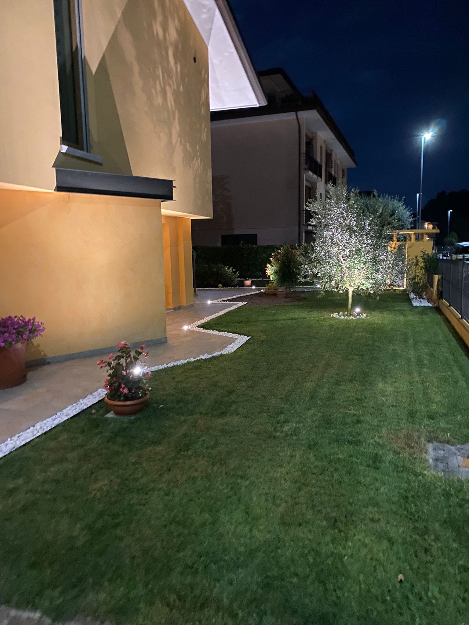 Giardino con illuminazione notturna e prato curato