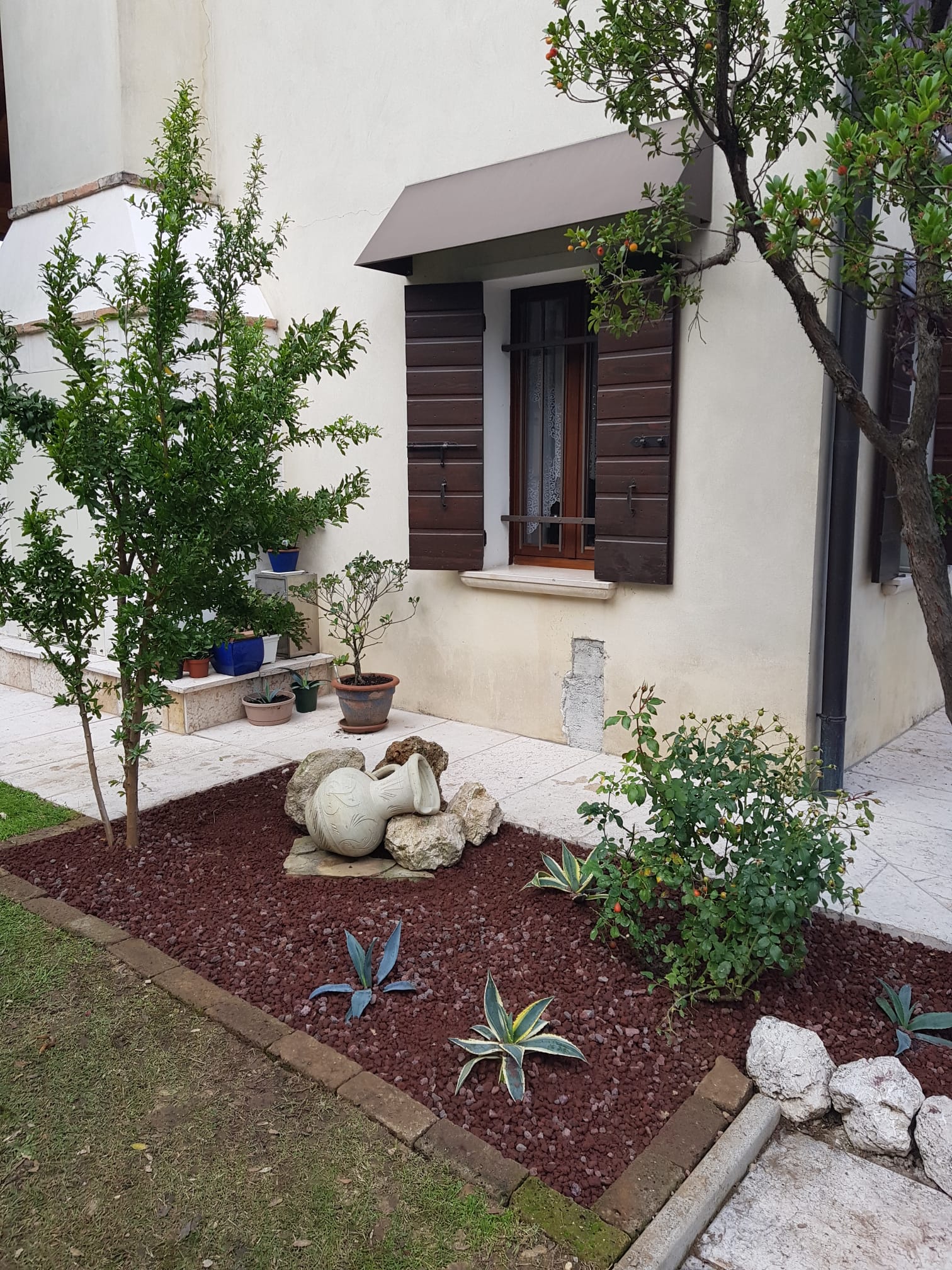 Aiuola con lavica rossa, piante grasse e sculture decorative