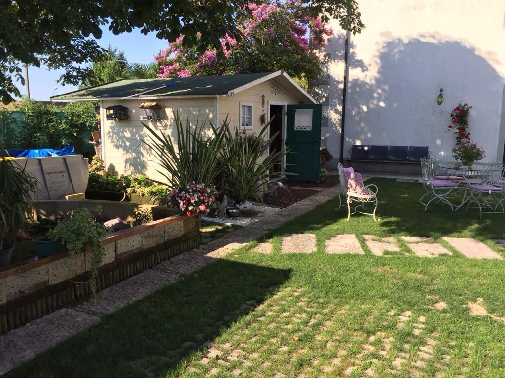 Giardino con casetta in legno e prato curato